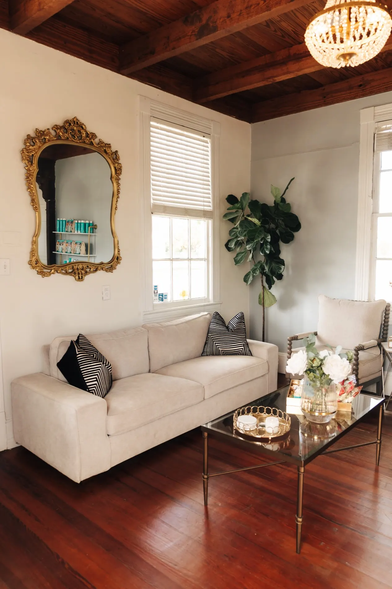 Salon lounge with gilded mirror and soft seating